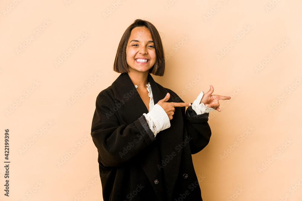 Young hispanic woman isolated excited pointing with forefingers away. Young hispanic woman isolated excited pointing with forefingers away.