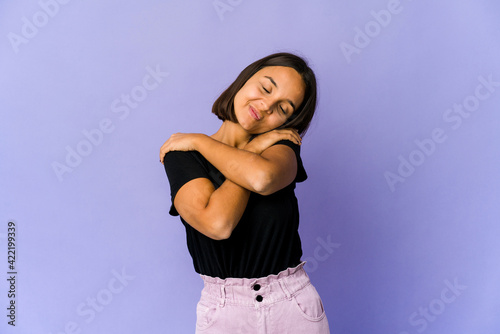 Young mixed race woman hugs, smiling carefree and happy.