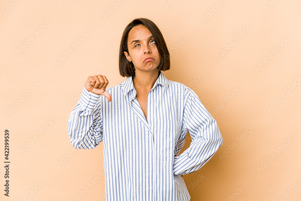 Young hispanic woman isolated showing a dislike gesture, thumbs down. Disagreement concept. Young hispanic woman isolated showing a dislike gesture, thumbs down. Disagreement concept.