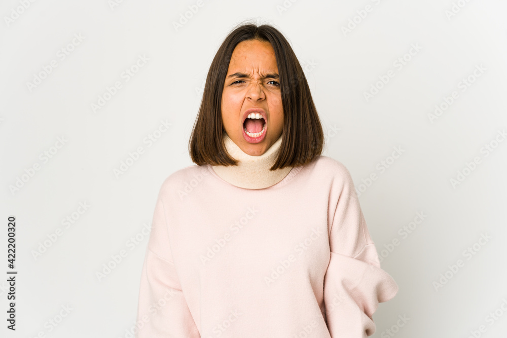 Young hispanic woman wearing a collar screaming very angry and aggressive. Young hispanic woman wearing a collar screaming very angry and aggressive.