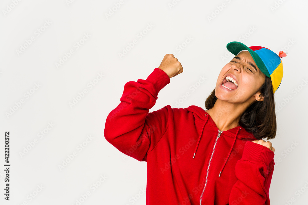 Young hispanic woman wearing a cap with propeller isolated raising fist after a victory, winner concept. Young hispanic woman wearing a cap with propeller isolated raising fist after a victory, winner concept.