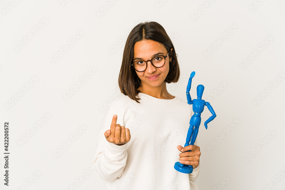 Young hispanic mixed race woman holding a wood doll pointing with finger at you as if inviting come closer. Young hispanic mixed race woman holding a wood doll pointing with finger at you as if inviting come closer.