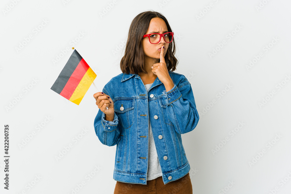 Young latin woman holding a german flag isolated on white background Young latin woman holding a german flag isolated on white background