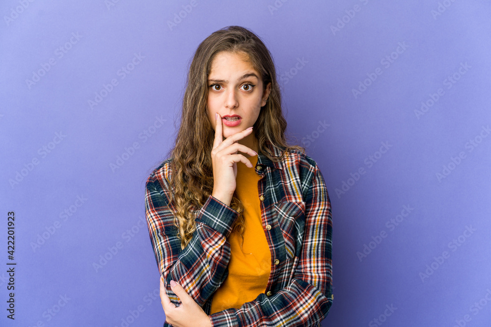 Young caucasian cute woman looking sideways with doubtful and skeptical expression.