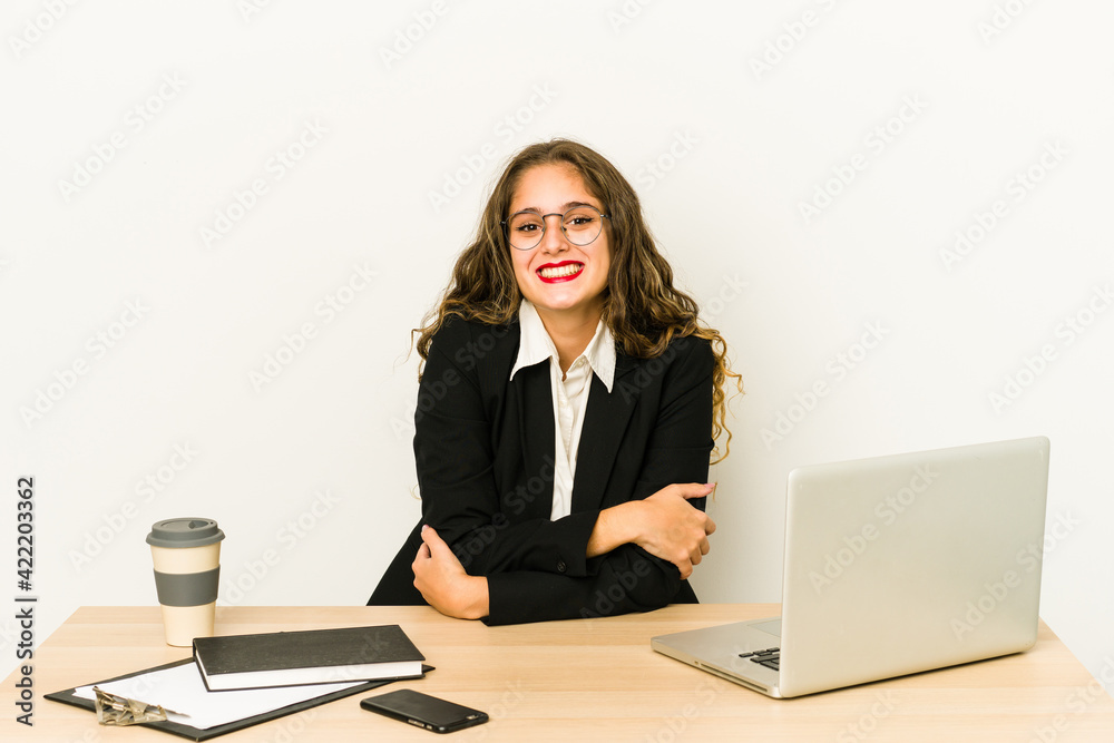 Young caucasian business woman working on her desktop isolated laughing and having fun. Young caucasian business woman working on her desktop isolated laughing and having fun.