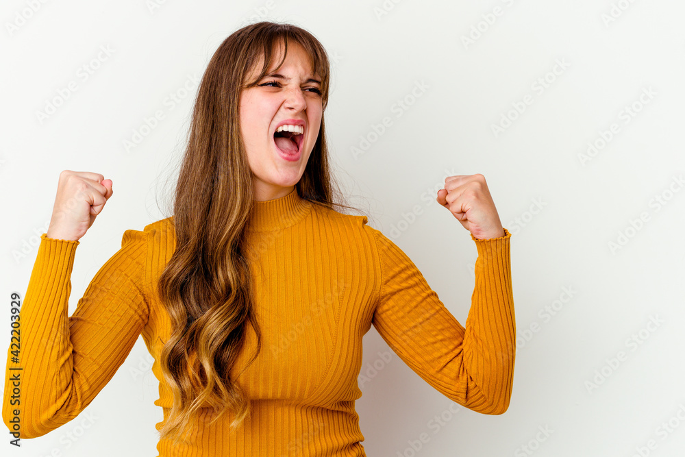 Young caucasian cute woman isolated on white background raising fist after a victory, winner concept. Young caucasian cute woman isolated on white background raising fist after a victory, winner concept.