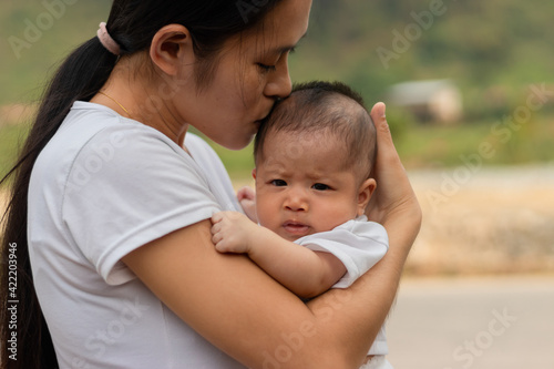 Young Asian mother holding little daughter in the park, Mother play enjoying with her cute baby girl outdoor, copy space 