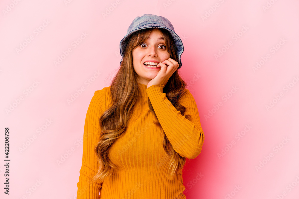 Young caucasian woman wearing fishermans hat isolated biting fingernails, nervous and very anxious.