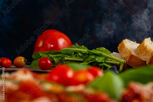 onion tomato basil tomato bread on wooden base and dark background