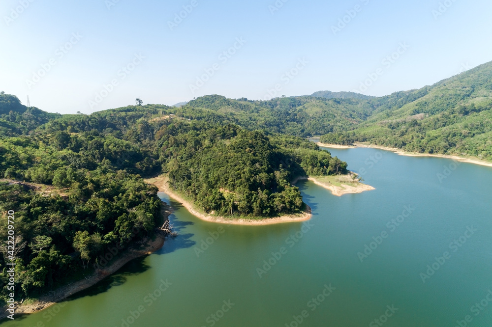 Aerial Drone shot bird eye view mountain lake with rainforest lake surrounded by mountains and reflection in the water