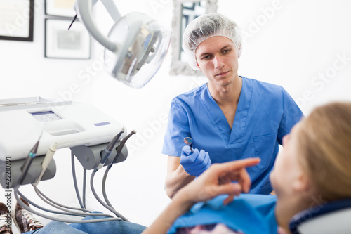 Dentist male in uniform is examinating of female in dental clinic. High quality photo