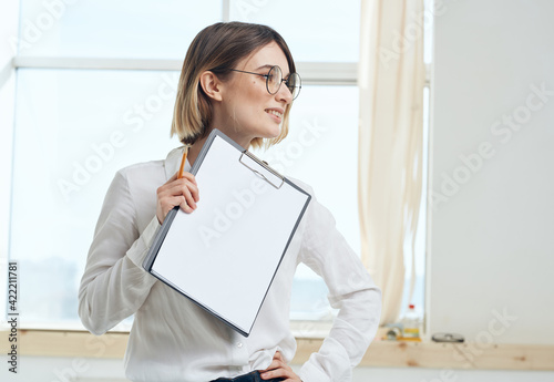 Woman rooming near window interior Folder with documents white sheet of paper mockup