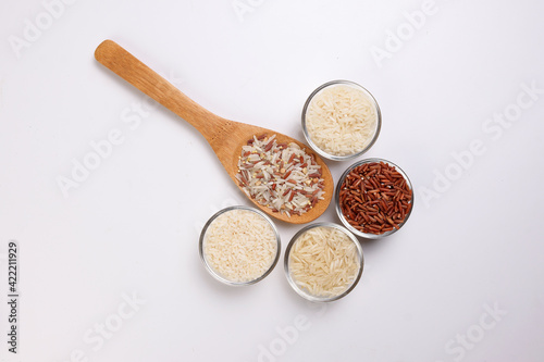 Long grain basmati medium grain jasmine short grain pilaf polau risotto brown low glycaemic index gi rice in small glass bowl wooden spoon on white background copy text space top flat lay view