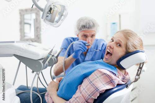 Male dentist treating young female patient in dental office. High quality photo