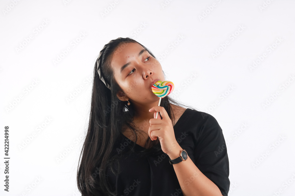 Fashion portrait young woman and lollipop is having fun over white background. Fashion portrait young woman and lollipop is having fun over white background.