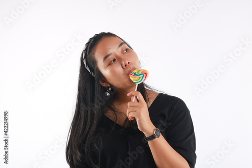 Fashion portrait young woman and lollipop is having fun over white background.