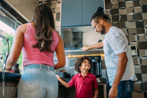 latinx family with their son have fun home together in the kitchen