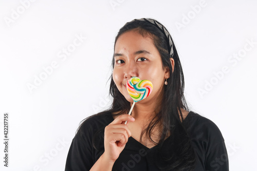 Fashion portrait young woman and lollipop is having fun over white background.