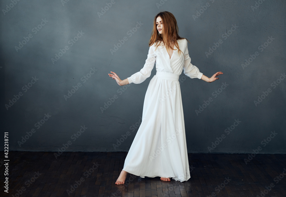 Woman in white dress on gray background red hair model romance Woman in white dress on gray background red hair model romance