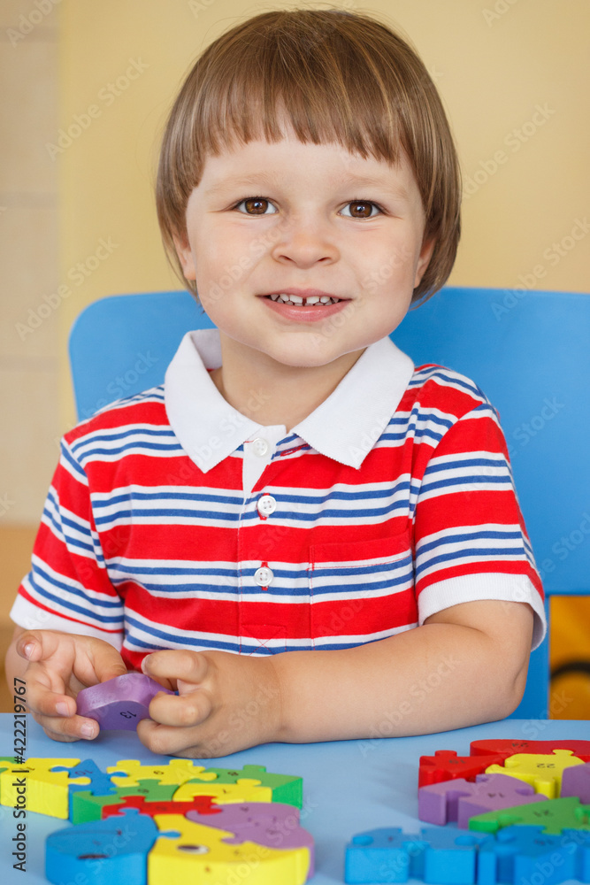 Happy preschooler playing with puzzle. Child development concept Happy preschooler playing with puzzle. Child development concept