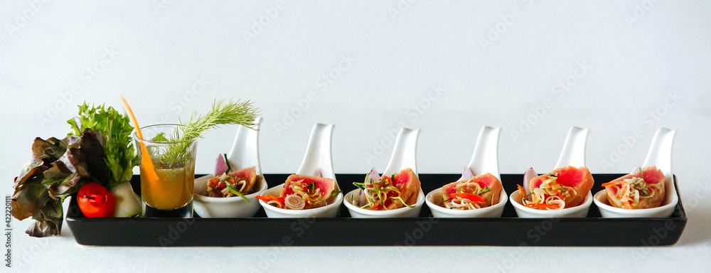 Εκτύπωση καμβά Snacks in white spoons with red potatoes or meat, with vegetables and sauce in a