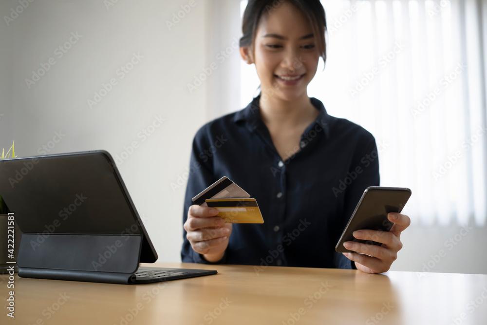 Happy young asian woman using smart phone and holding credit card for online banking or online shopping. Happy young asian woman using smart phone and holding credit card for online banking or online shopping.