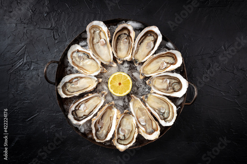 Oysters. A platter of a dozen fresh oysters with lemon