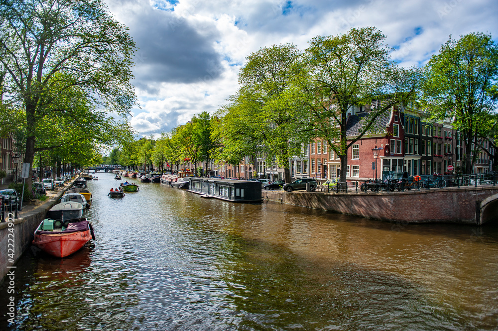 Amsterdam, Netherlands - July 7, 2019: Amsterdam canals and traditional Dutch houseboats on a summer day in the Netherlands