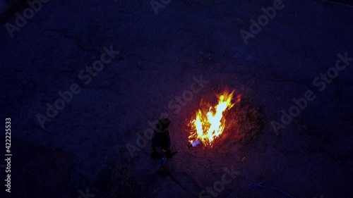 Flamethrower igniting brush, top-down at 10 degree angle. Dark nondescript male subject photo