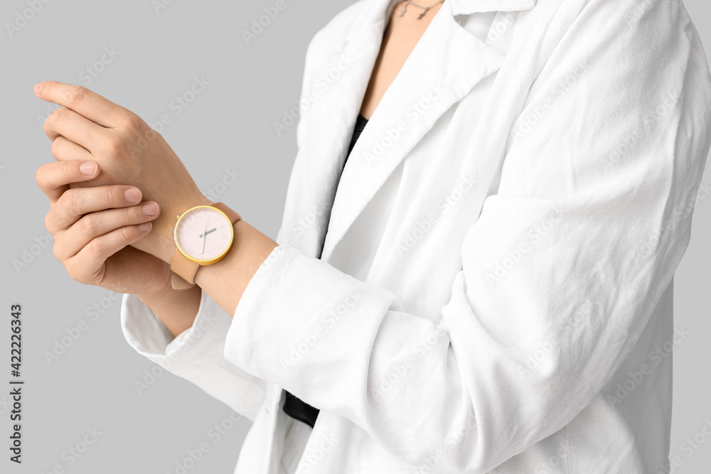 Woman with stylish wrist watch on light background Woman with stylish wrist watch on light background