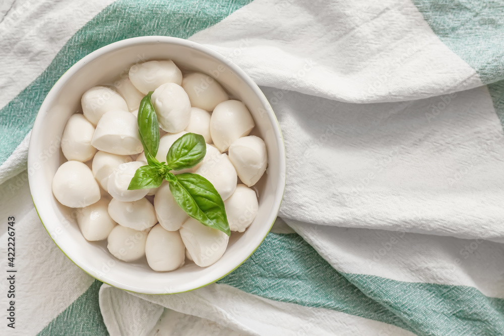 Bowl with mozzarella cheese on fabric background Bowl with mozzarella cheese on fabric background