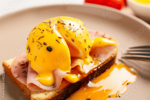Tasty egg Benedict on plate, closeup