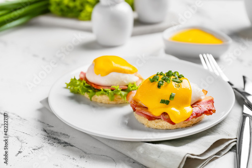 Quadro em tela Plate with tasty eggs Benedict on light background