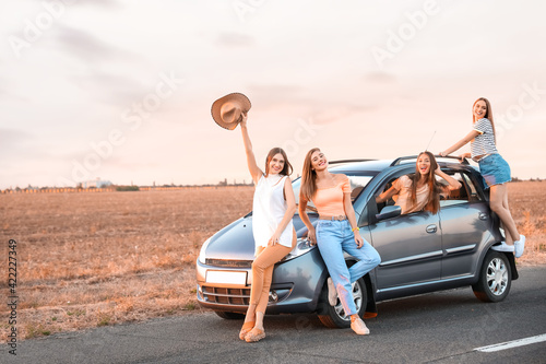 Happy young women near modern car © Pixel-Shot