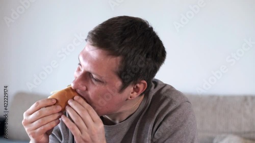 The man is eating a hot dog. Eating foods high in carbohydrates