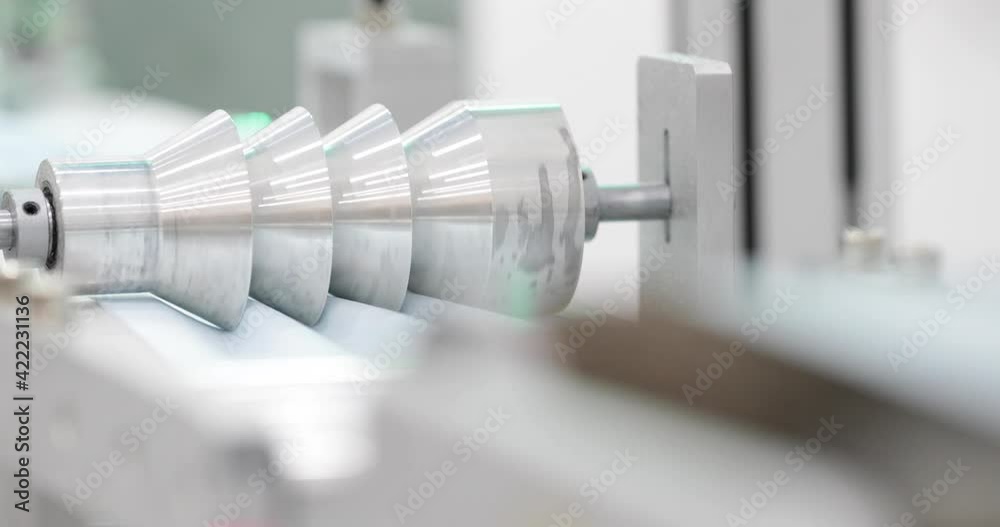 Surgical Mask Fabric Material Passing Through Folding Wheel At Mask Making Machine. - close up
