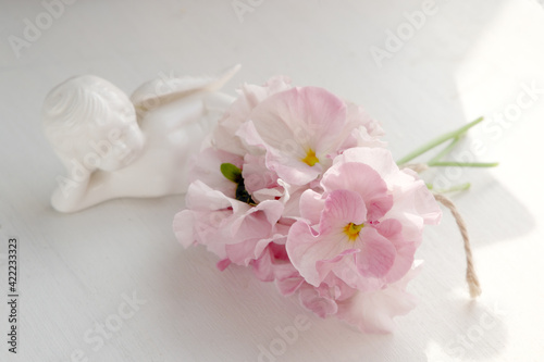 ピンクのパンジーの花束と白い天使横