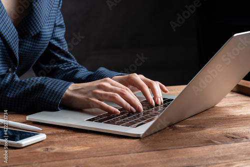Business lady typing on laptop computer at desk