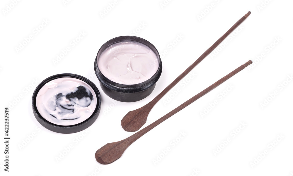 Creamy pink lotion with wooden spoons isolated Creamy pink lotion with wooden spoons isolated