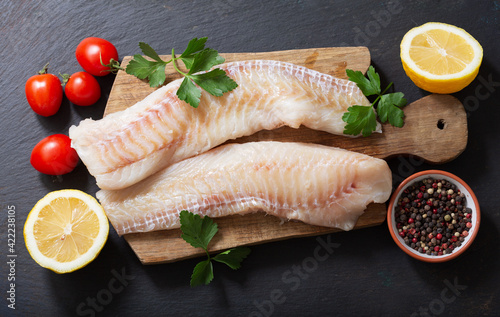 fresh fish fillet of cod with ingredients for cooking,  top view