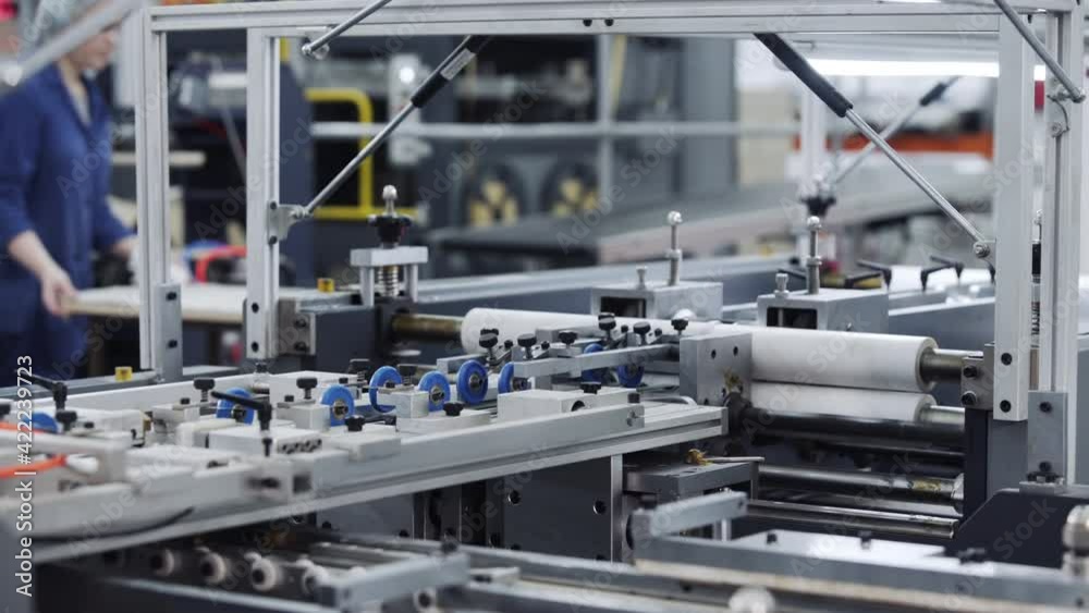Modern automatic conveyor line for the production of package. Modern factory of production cardboard box. Manufacture of cardboard boxes from paper. Enterprise for production package Modern automatic conveyor line for the production of package. Modern factory of production cardboard box. Manufacture of cardboard boxes from paper. Enterprise for production package
