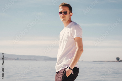 man with sunglasses walking on the beach