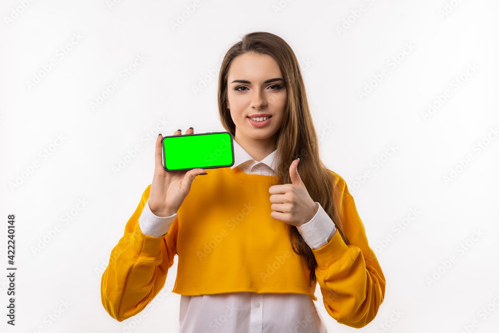 Pretty young brunette womanis showing smartphone blank screen in her hand Pretty young brunette womanis showing smartphone blank screen in her hand