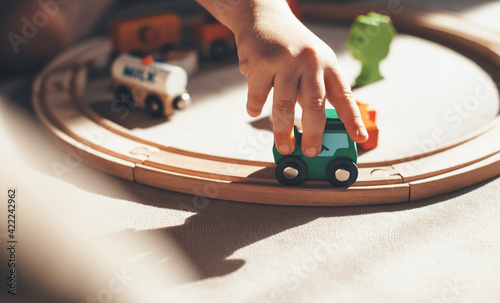 Картината върху платно caucasian kid is playing with toy train on the railway on the floor