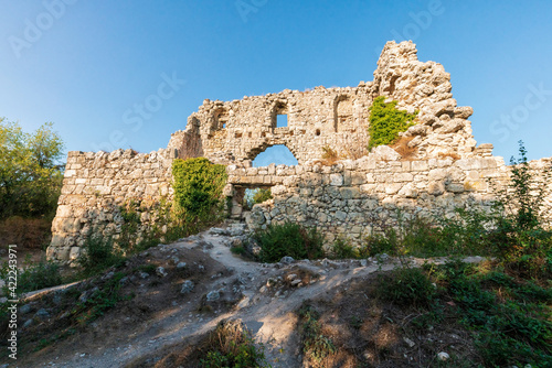 Mangup-Kale is an ancient cave town in Crimea. View of antique citadel ruins at sunset.