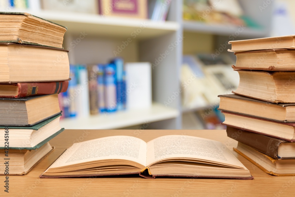 Stack open old books on wooden desk Stack open old books on wooden desk
