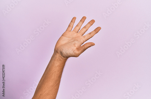 Arm and hand of caucasian young man over pink isolated background presenting with open palm  reaching for support and help  assistance gesture