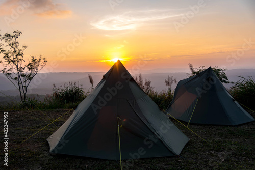 silhouette of camping tents with sunset view