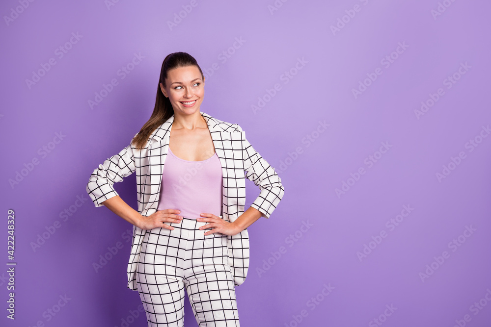 Photo of attractive glamour young woman hold hands waist look empty space smile isolated on purple color background Photo of attractive glamour young woman hold hands waist look empty space smile isolated on purple color background