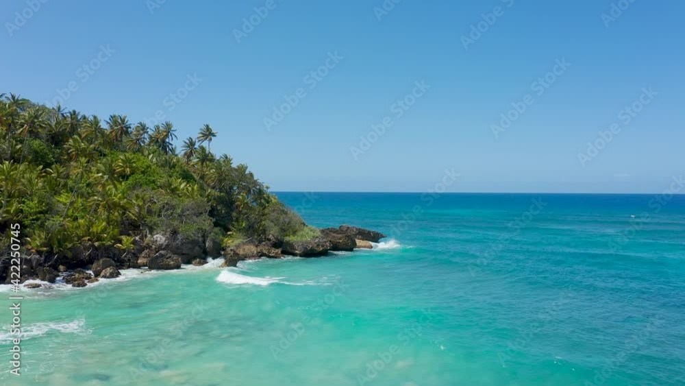 A beautiful palm peninsula with a rocky coastline in the Atlantic Ocean. Bright turquoise water beats against the stone coast of the island. Beautiful seascape on a sunny day. A beautiful palm peninsula with a rocky coastline in the Atlantic Ocean. Bright turquoise water beats against the stone coast of the island. Beautiful seascape on a sunny day.